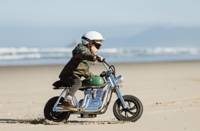 small kid on motorcycle at the beach